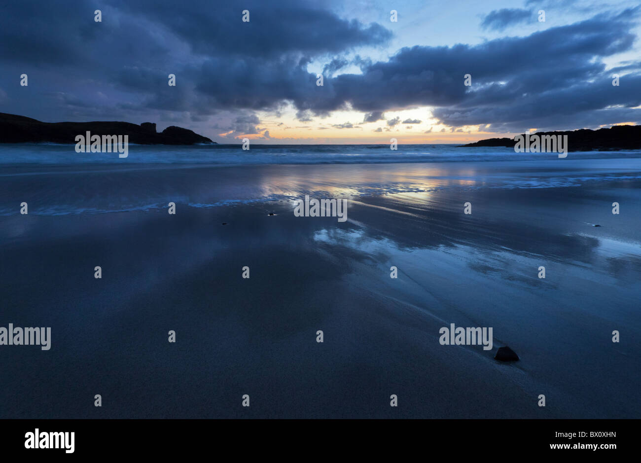La riflessione di nuvole sulla spiaggia a Clachtoll Bay a nord ovest Highlands della Scozia. Foto Stock