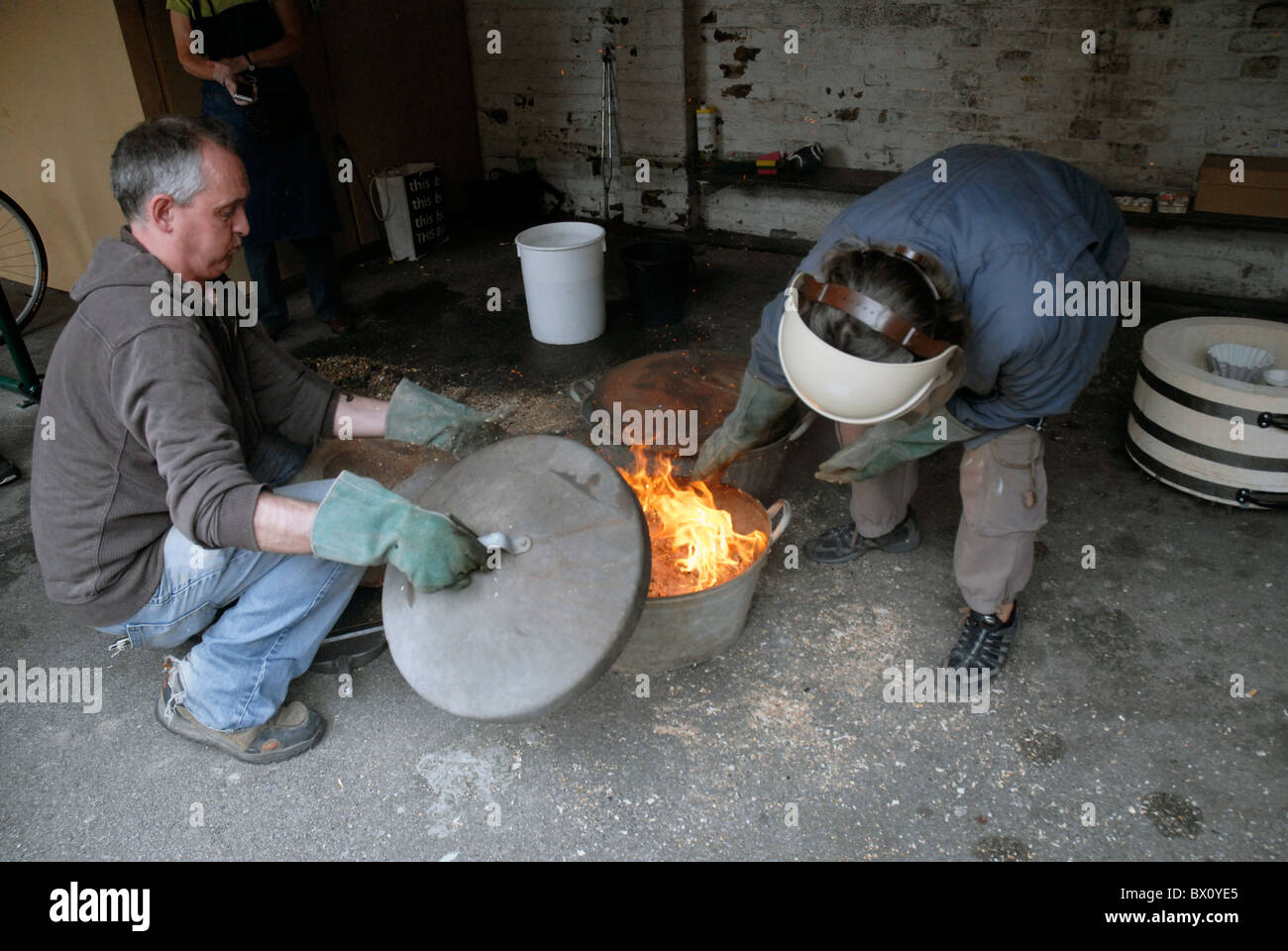 Fare ceramica Raku utilizzando un tradizionale riservato di cottura in ceramica Foto Stock