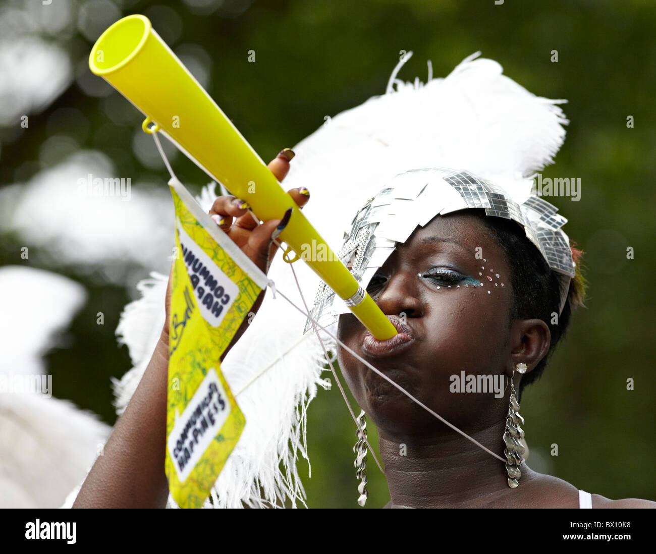 West donna indiana a soffiare una tromba in Costume Il carnevale di Notting Hill Londra REGNO UNITO Foto Stock