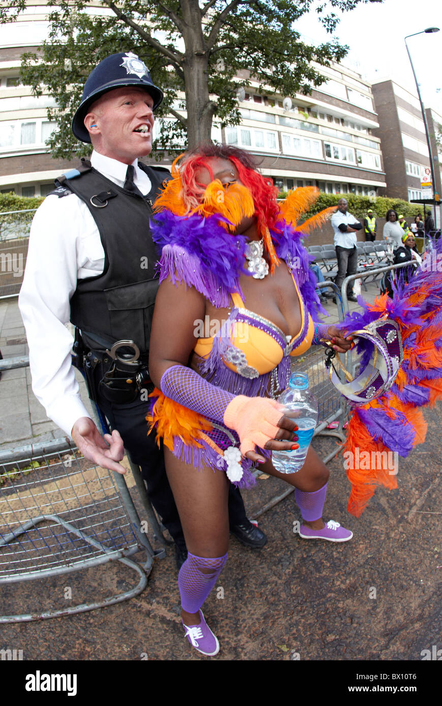 West Indian donna in costume con un poliziotto britannico il carnevale di Notting Hill Londra REGNO UNITO Foto Stock