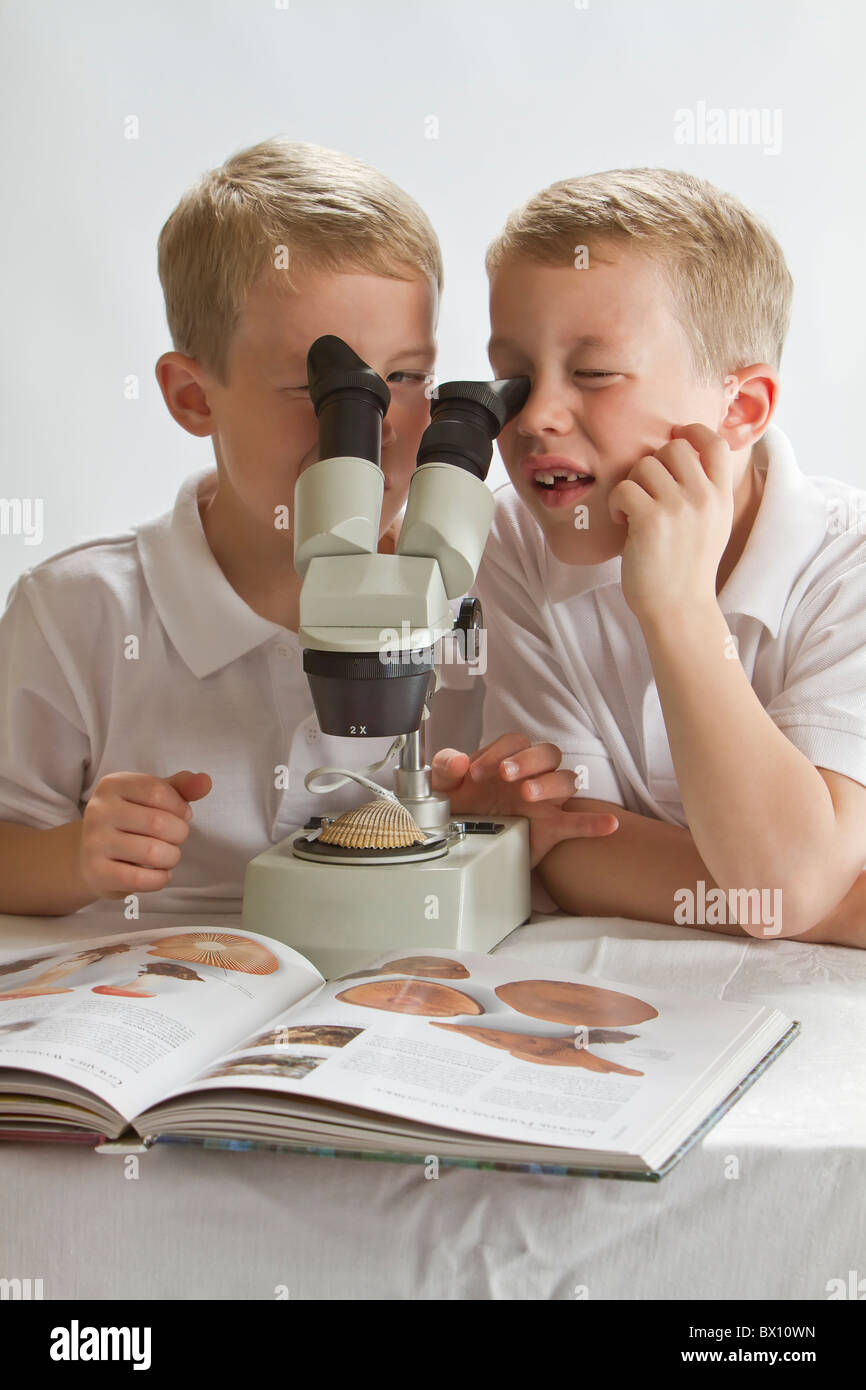 I fratelli gemelli, giovani scienziati in cerca di un microscopio - apprendimento Foto Stock