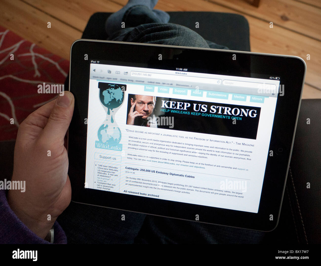 L'uomo la lettura di Wikileaks sito web su un computer tablet iPad Foto Stock