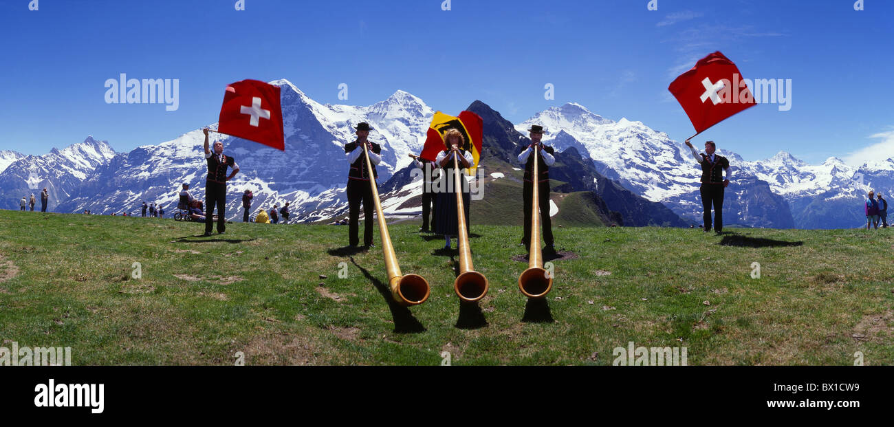 Bandiera Alphorn thrower tradizione costumi nazionali folklore sfondo Mannlichen Eiger Monch Jungfrau Switzerla Foto Stock