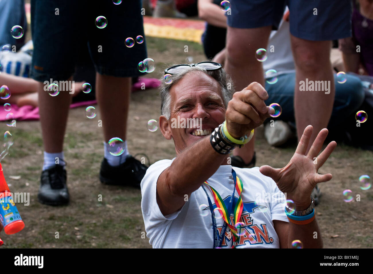 L'uomo cattura bolle in una folla Foto Stock