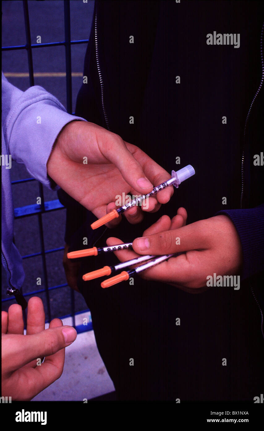 Addiction tossicodipendenti ai concessionari che trattano di droghe illegali le mani sociale dei bambini di strada di siringhe adolescenti scambi yo Foto Stock