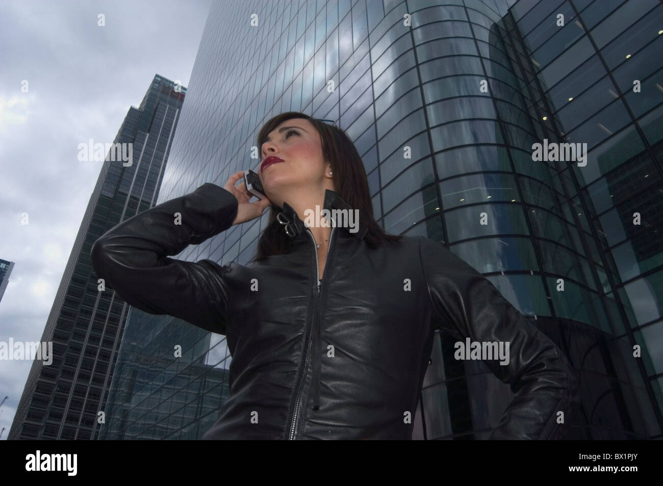 Edificio nero chiamata business fino al di fuori della costruzione facciata di vetro pelle giacca in pelle stile di vita mobile Foto Stock