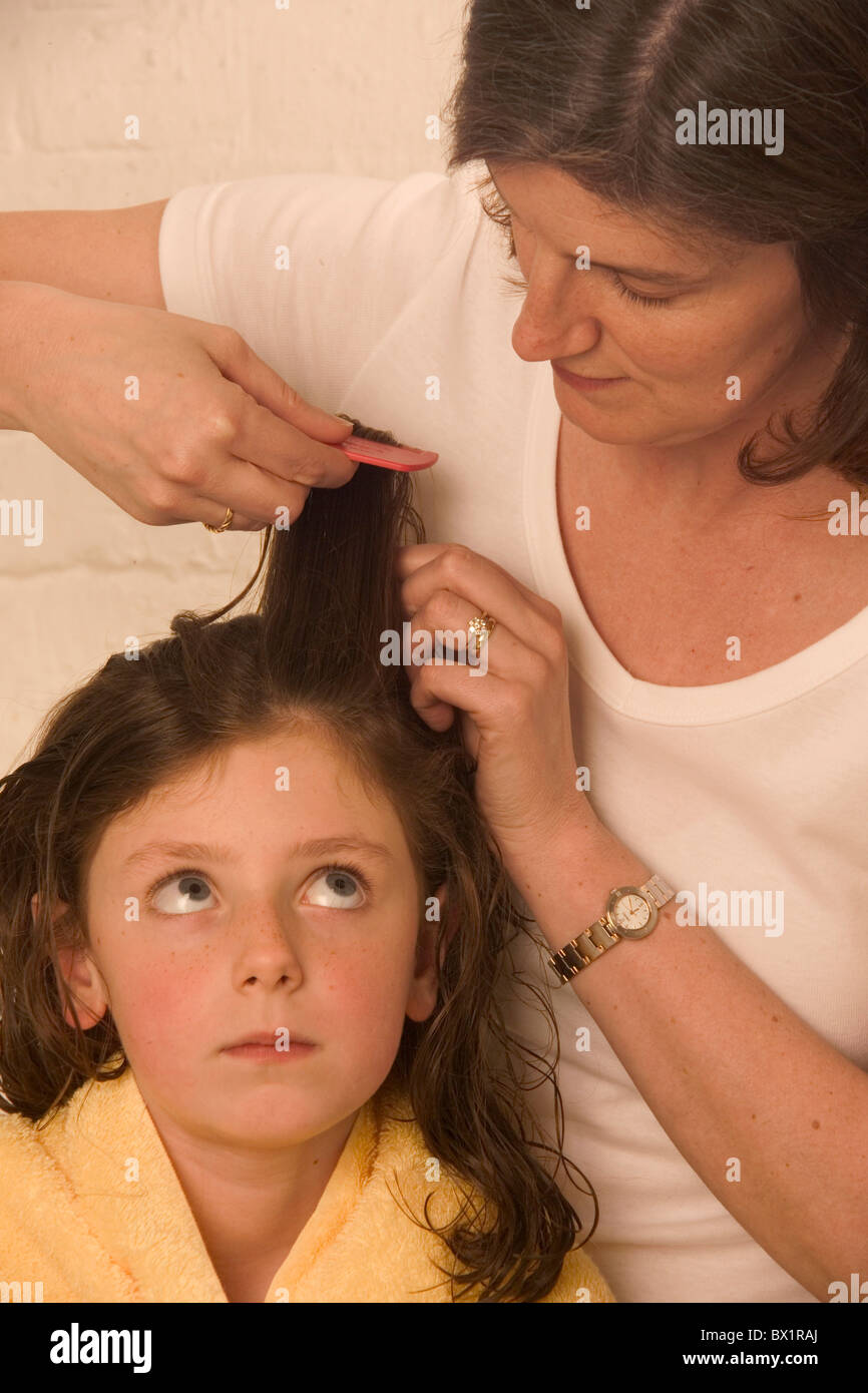 Attenzione a controllare il comando a pettine famiglia figlia ragazze pettini capelli ispezionare i pidocchi madre parassita di precauzione allievo Foto Stock