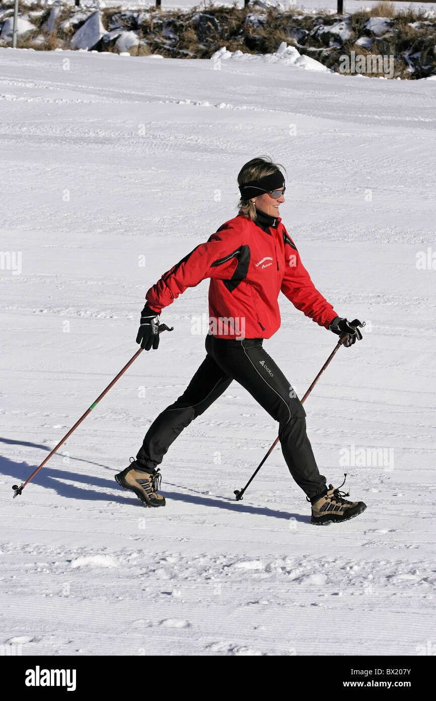 Il Nordic Walking inverno Donna che cammina in esecuzione piani bastoni sport per il tempo libero sport invernali sport neve Foto Stock