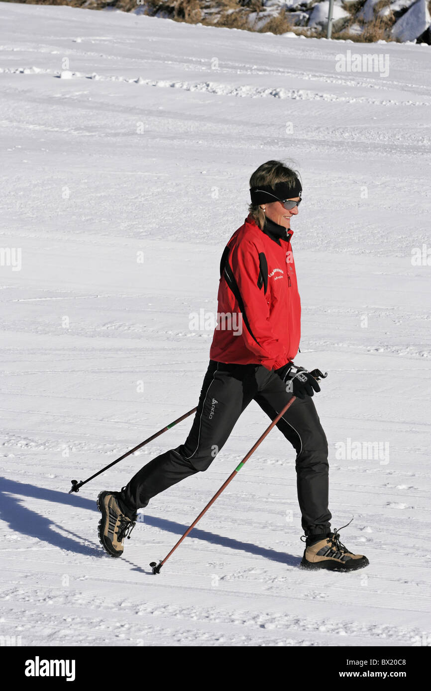 Il Nordic Walking inverno Donna che cammina in esecuzione piani bastoni sport per il tempo libero sport invernali sport neve Foto Stock