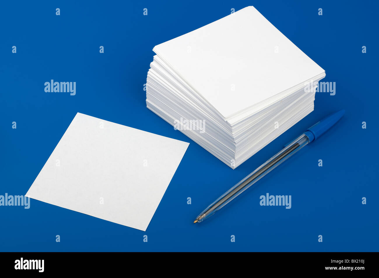 Pila di bianco quadrato nota carta e penna biro Foto Stock