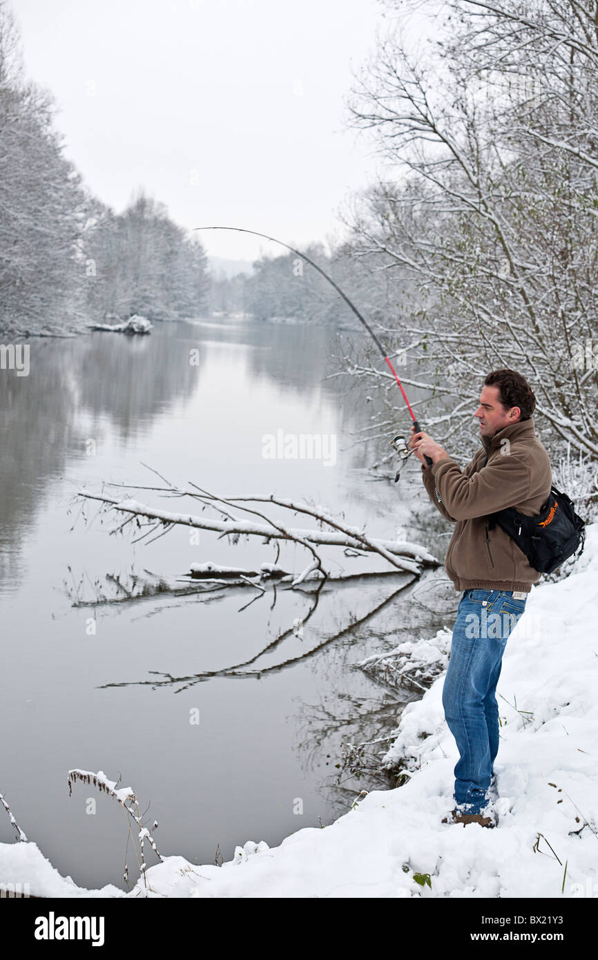 In inverno, un pescatore sulla riva del fiume Allier (Francia). Pêcheur à la ligne sur une des berges de l' Allier, en hiver. Foto Stock
