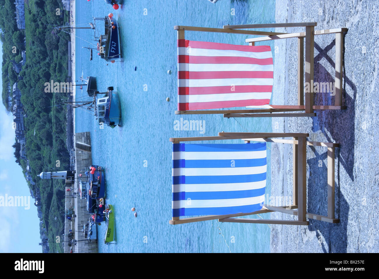 Spiaggia Spiaggia sedie barche costa costa luogo piccola città Cornwall sedie a sdraio Inghilterra Europa porto di pesca G Foto Stock