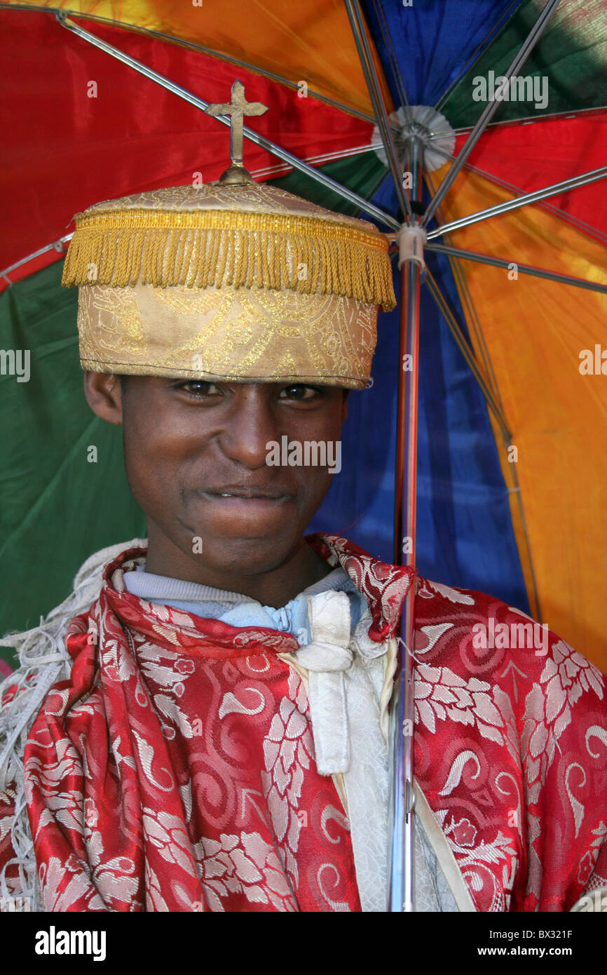 Giovane sacerdote con ombrello coloratissimo, Addis Abeba, Etiopia Foto Stock