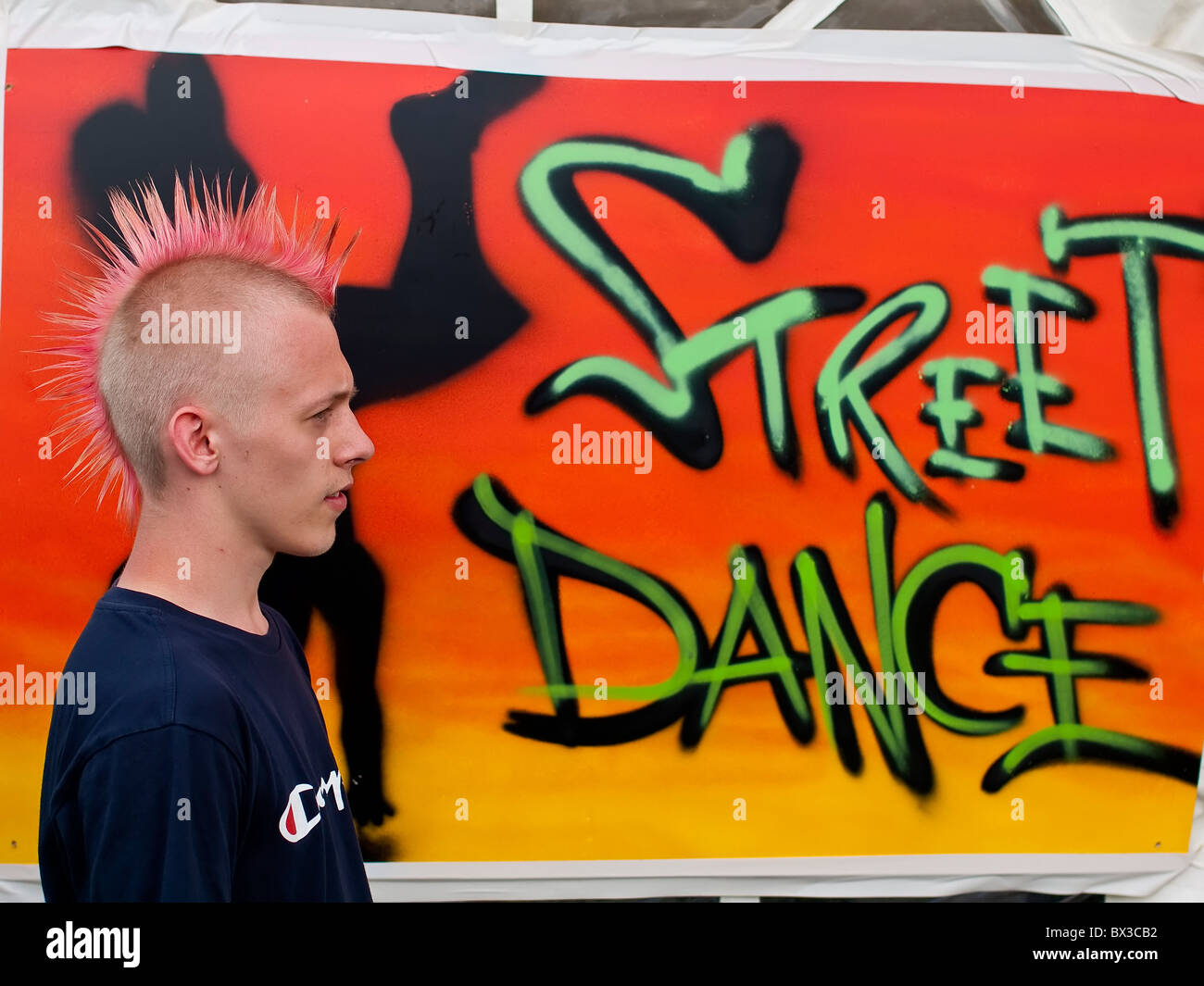 Adolescente con Punk acconciatura al Festival con sfondo del segno luminoso Foto Stock