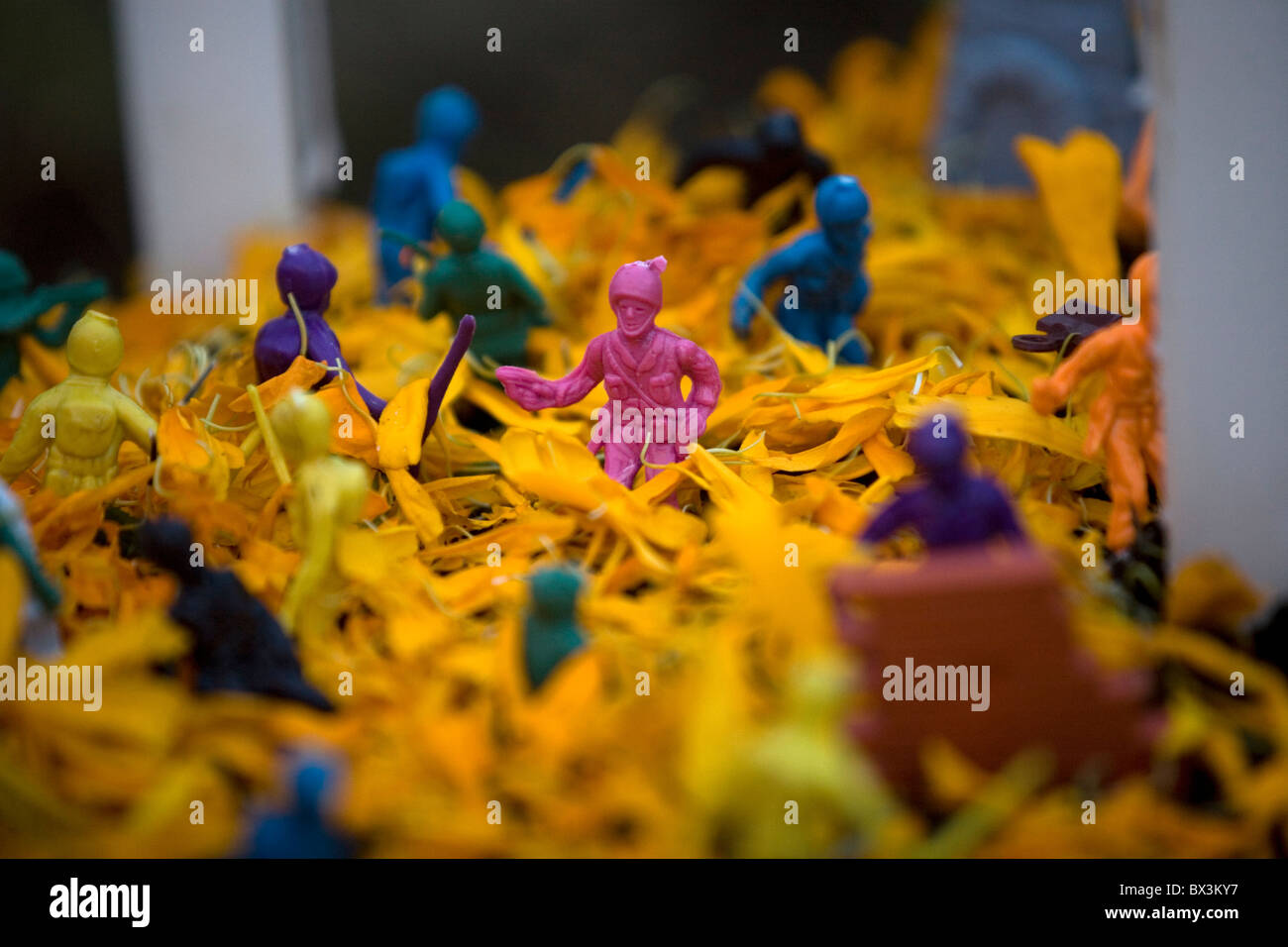 Giocattolo di plastica soldati decorare una tomba ornata di giallo fiori di tagete come parte del Giorno dei Morti celebrazioni in Città del Messico Foto Stock
