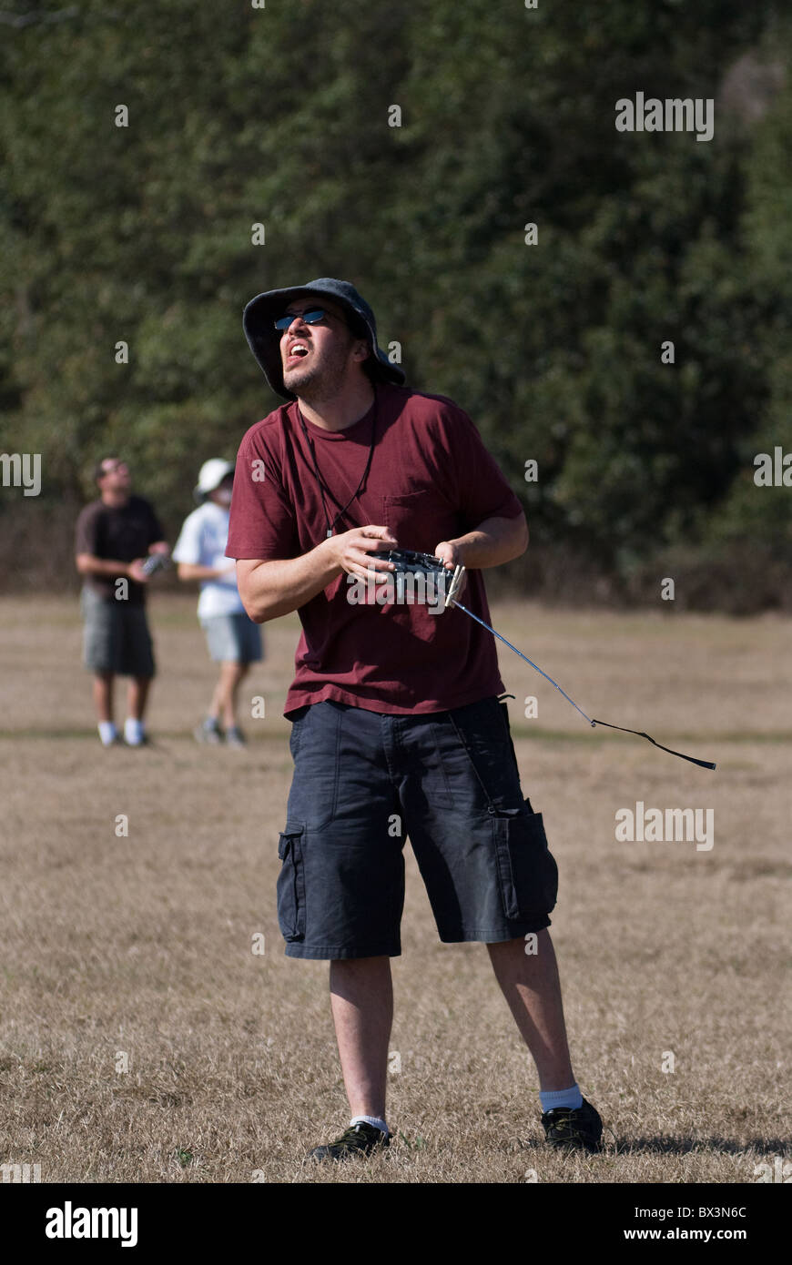 L'uomo utilizza la radio del dispositivo di comando a battere il suo lancio a mano glider durante la competizione, Alachua, Florida. Foto Stock