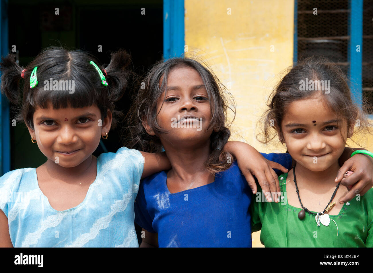 Sorridendo felice villaggio indiano ragazze in piedi di fronte a casa loro. Andhra Pradesh, India Foto Stock
