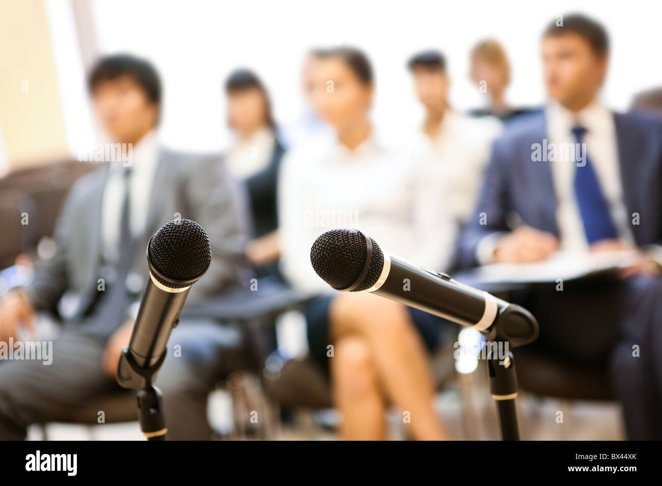 Immagine di due microfoni sullo sfondo delle persone che ascoltano la lezione a una conferenza Foto Stock