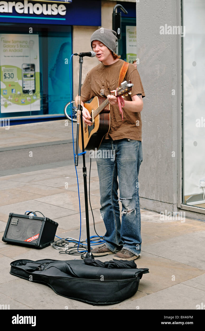 Busker musicista di strada su una strada di città di Oxford, UK. Foto Stock