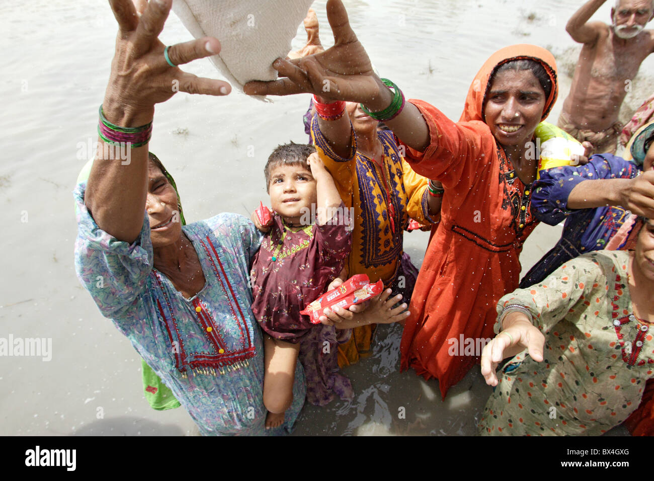 Vittime delle inondazioni getting di forniture di soccorso, Shadhat Kot, Pakistan Foto Stock