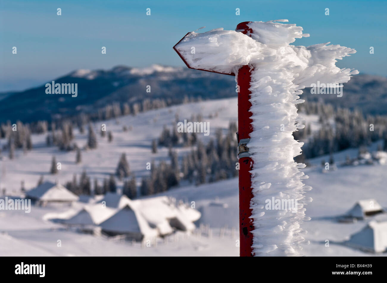 Un segnavia accumulo di neve da un costante vento di ponente a Velika planina, Slovenia. Foto Stock