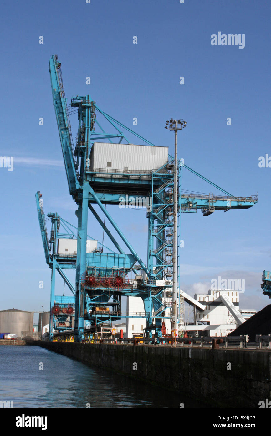 Gru stare accanto a cumuli di carbone a Liverpool Docks, REGNO UNITO Foto Stock