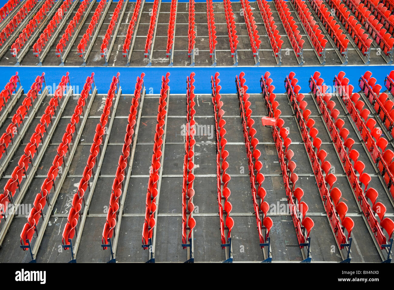 File di sedili rosso a Londra Olympia, uno con la base del sedile verso il basso Foto Stock