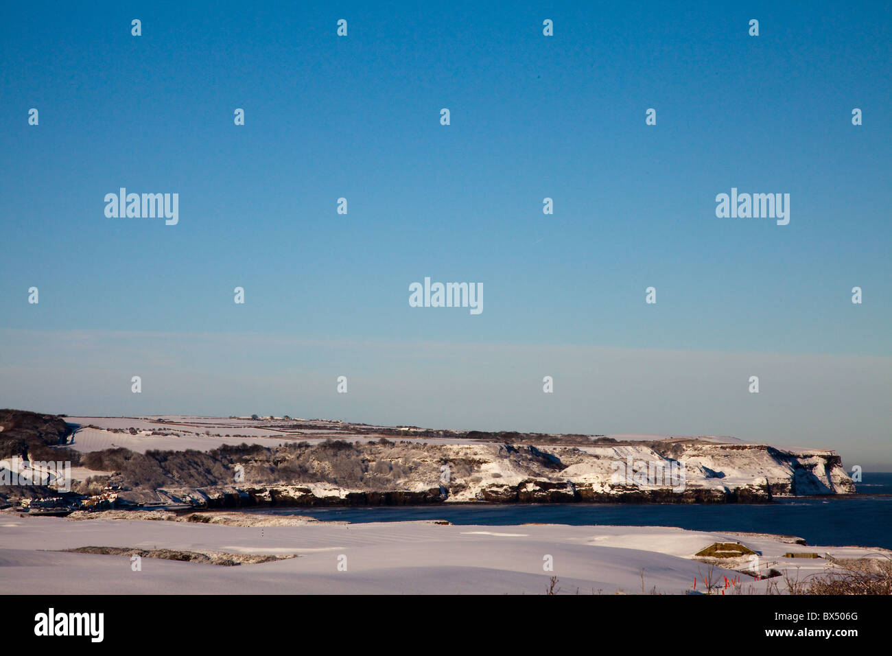 Coperta di neve colline e scogliere di Sandsend in una giornata di sole Foto Stock
