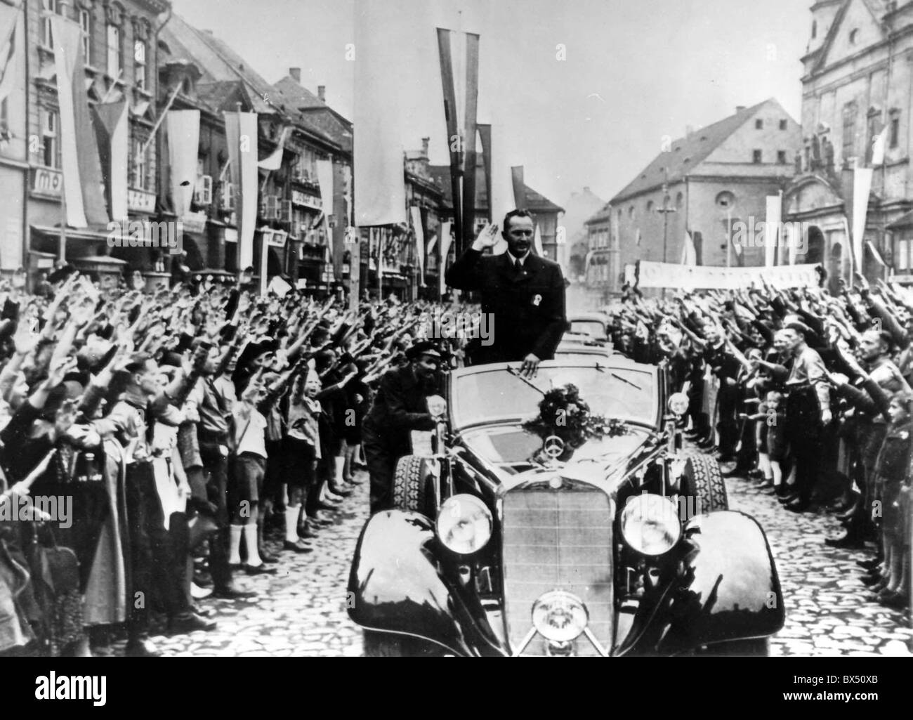 Sudeti i cittadini tedeschi a wave di Sudeti tedesco leader del Partito Konrad Henlein come egli drive through Chomutov Cecoslovacchia il lug. Foto Stock