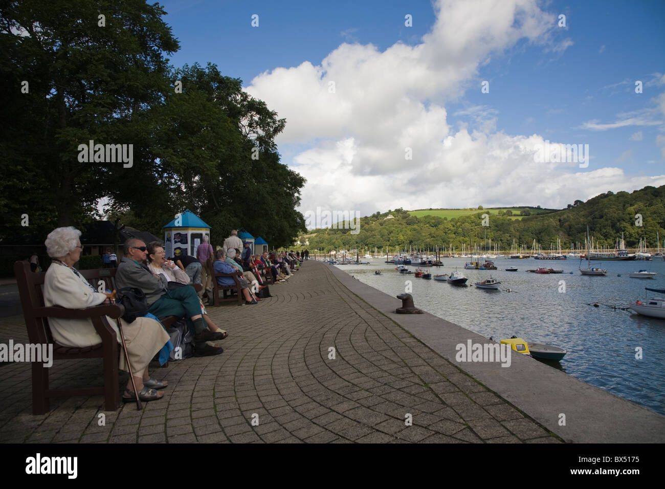 I pensionati seduti sulle rive del fiume Dart Foto Stock