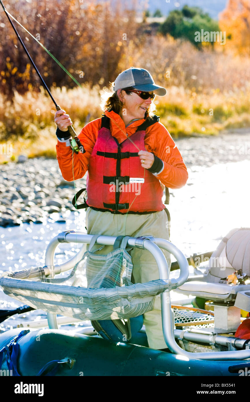 Donna di Pesca a Mosca Report di Pesca da una barca sul fiume Arkansas, vicino Salida, Colorado, STATI UNITI D'AMERICA Foto Stock