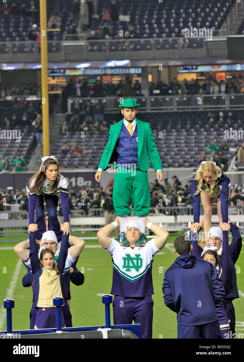 Notre Dame squadra Cheerleading e mascotte pratica prima del gioco del calcio vs. Army, lo Yankee Stadium, Bronx NY Foto Stock