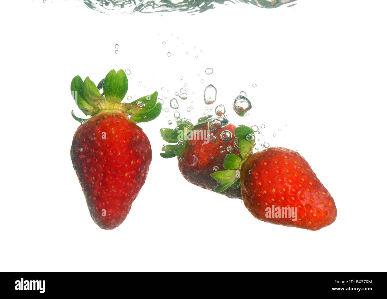Schizzi di fragole fresche ad acqua con bolle di aria Foto Stock