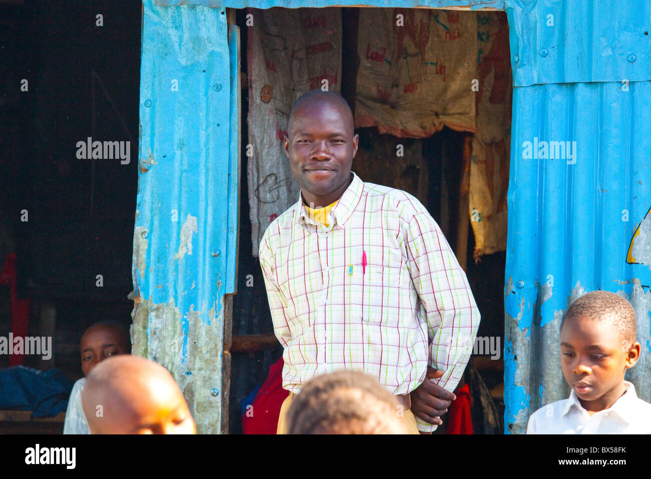 Giovane insegnante in Maja Mazuri Scuola, Mathare slum, Nairobi, Kenia Foto Stock
