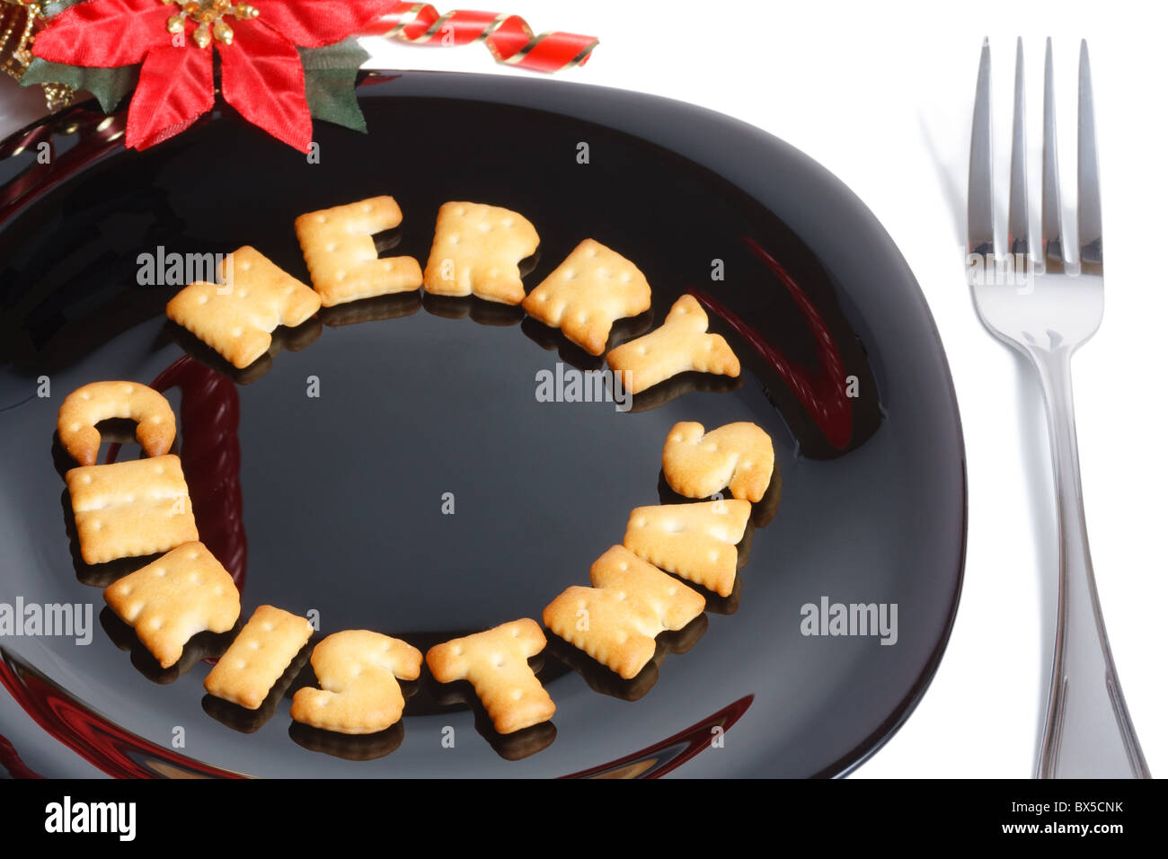 La piastra nera con carattere di biscotti a forma di forcella e decorazione di Natale isolato su bianco Foto Stock