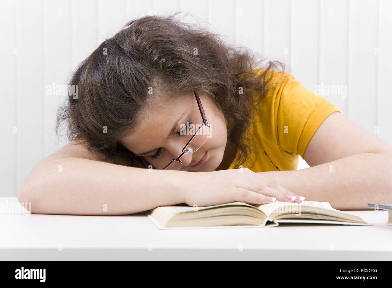 La giovane donna lo studente è addormentato sul libro aperto Foto Stock