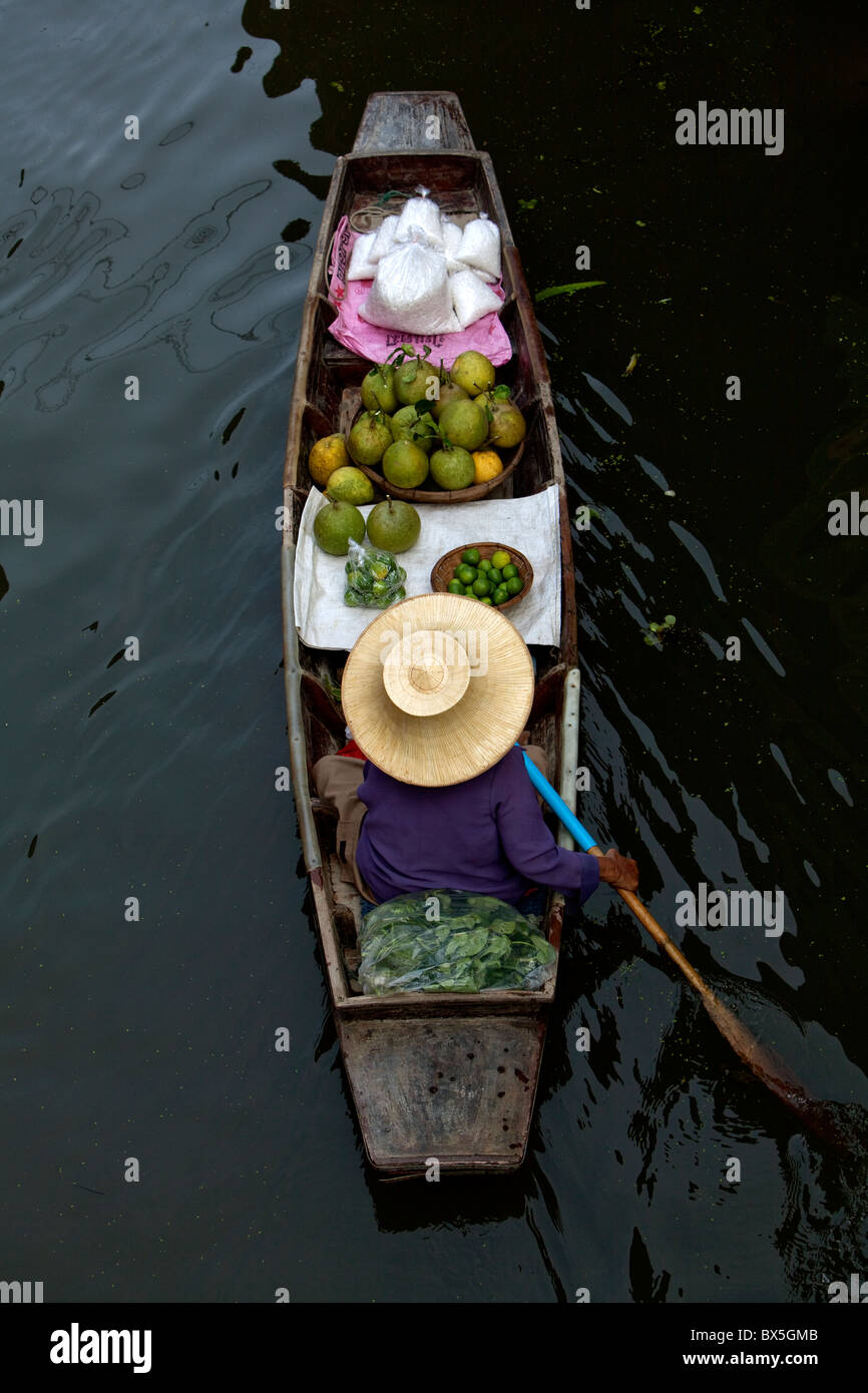 Marketing flottante, donna paddling una barca con frutti Foto Stock