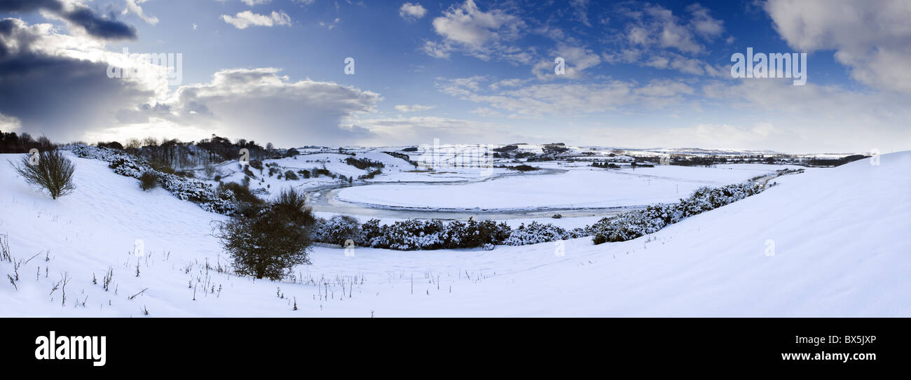 Vista panoramica del paesaggio innevato sotto il cielo invernale guardando verso serpeggiante Fiume Aln, Lesbury, Northumberland, Regno Unito Foto Stock