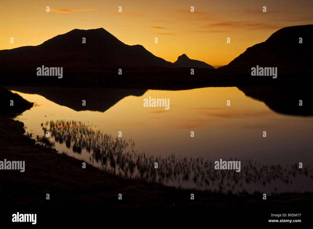 Sunset silhouette a Lochan un AIS, Inverpolly, Sutherland, a nord-ovest della Scozia, Regno Unito, Europa Foto Stock