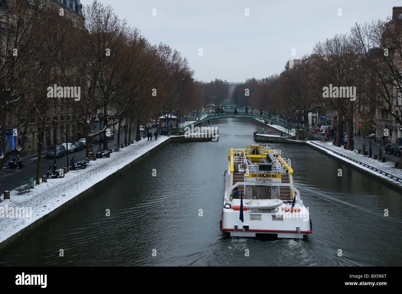 Bateaubus viaggiando lungo il Canal St Martin a Parigi nella neve. Foto Stock