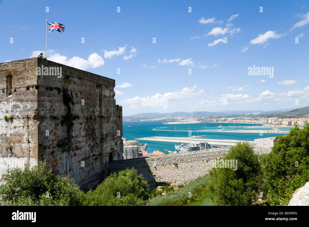 Guardando verso la Spagna su Gibilterra pista di aeroporto con castello moresco la Torre dell'Omaggio in primo piano dalla Rocca di Gibilterra. Foto Stock
