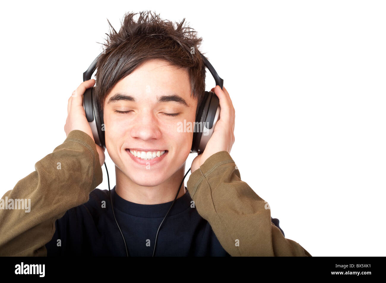 Adolescente maschio ascoltando la musica attraverso le cuffie. Isolato su sfondo bianco. Foto Stock
