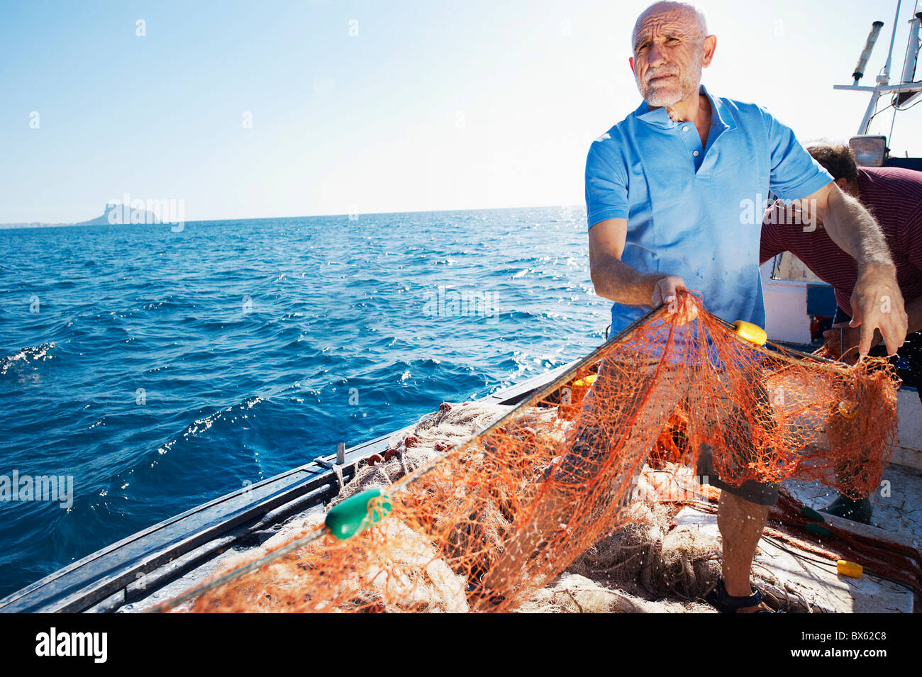 Pescatore sulla barca tirando in reti Foto Stock