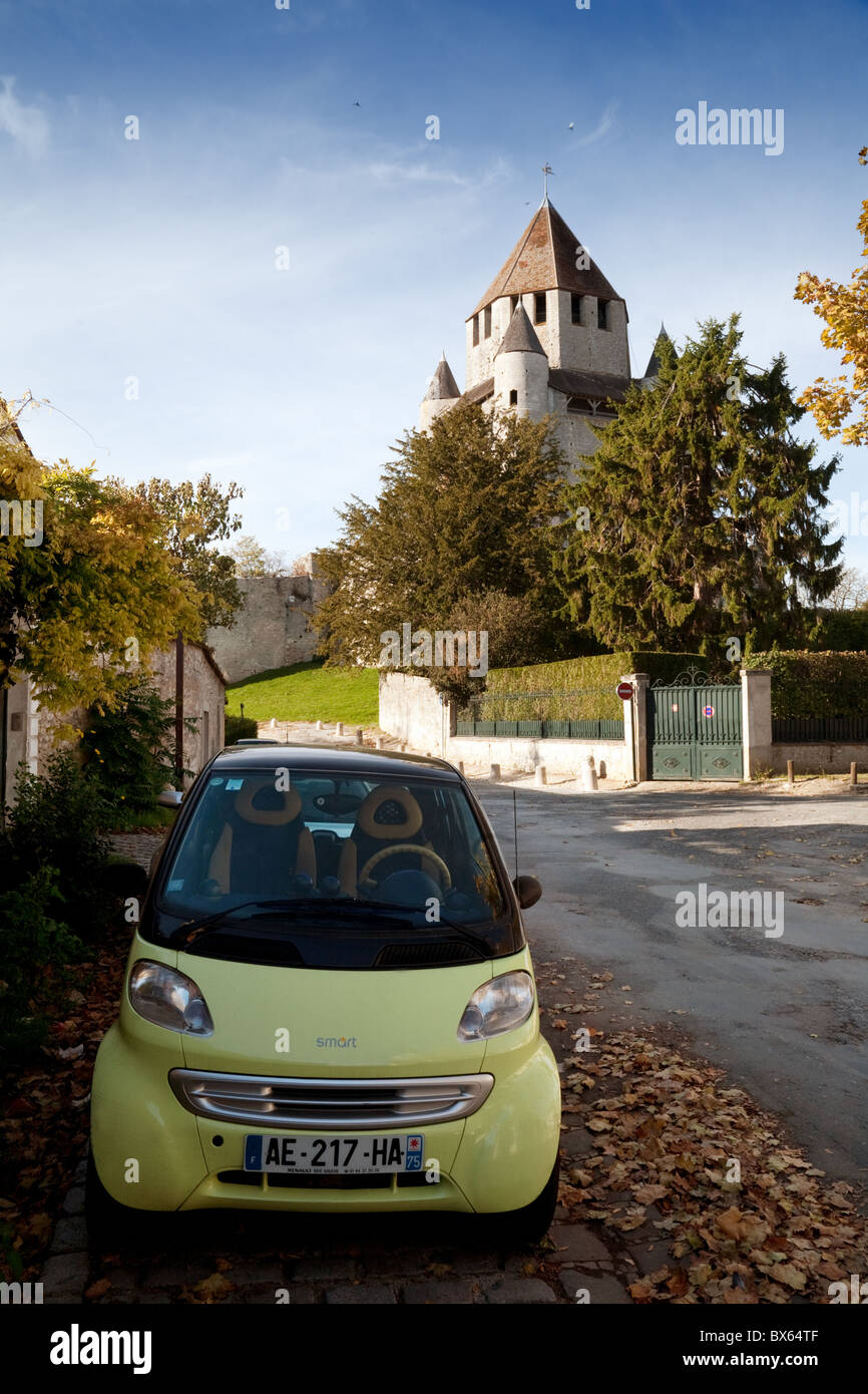 Una Smart auto parcheggiate lungo la strada con il Caesars Tower in background, Provins, Seine et Marne Francia Foto Stock