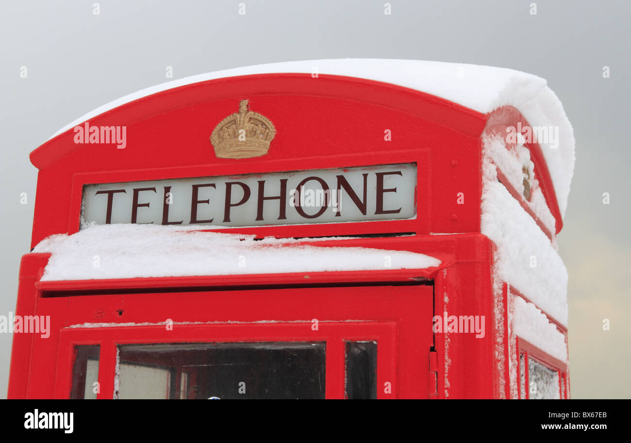Un vecchio telefono rosso box nella neve. Foto Stock