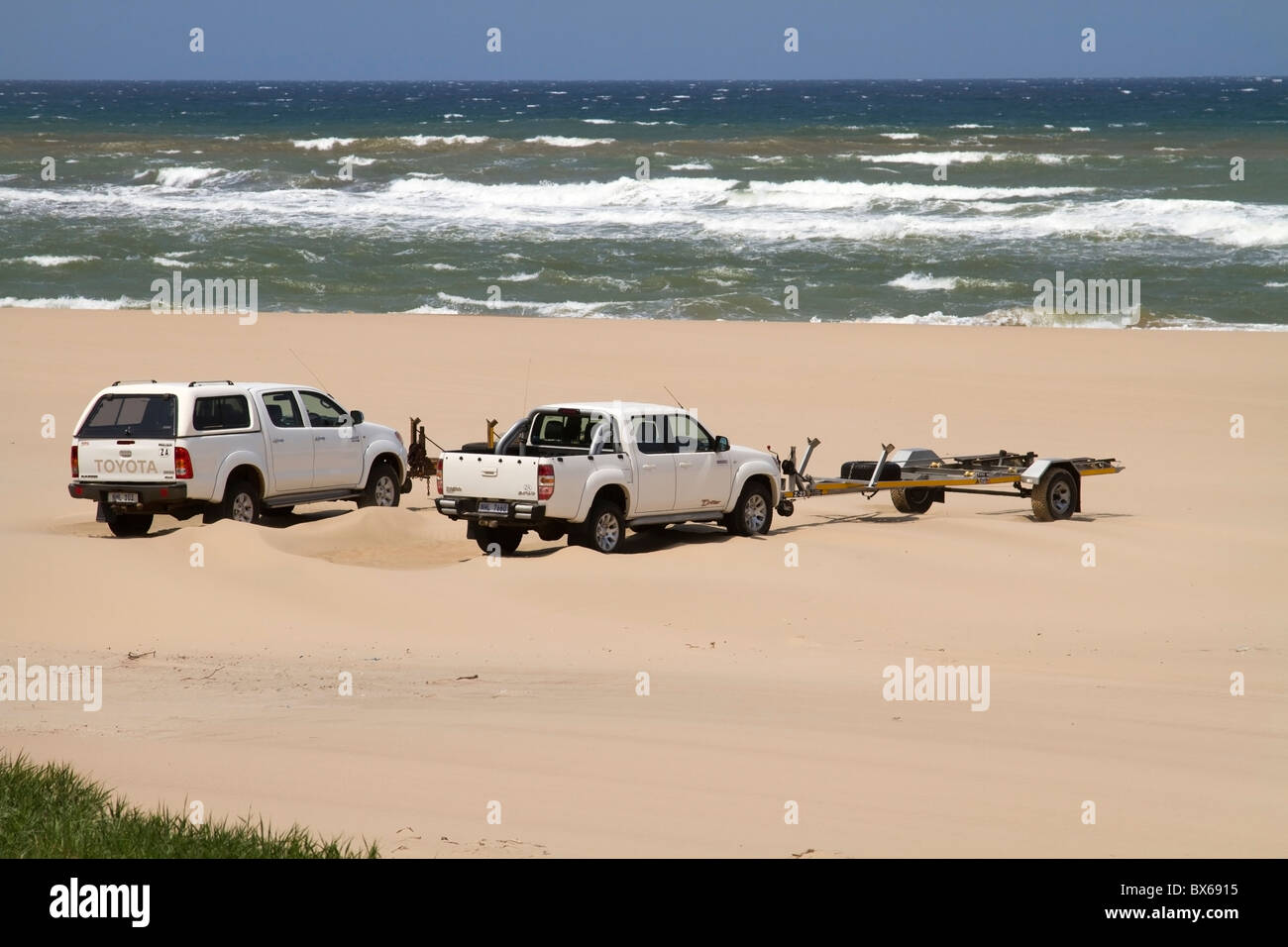 I veicoli sulla spiaggia con barca rimorchi a Cape Vidal, iSimangaliso Wetland Park, Kwazulu Natal, Sud Africa Foto Stock
