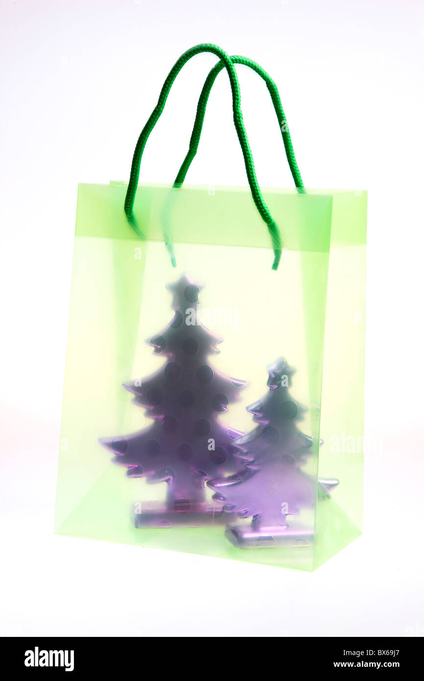 Colorato borsa regalo, riempito con un piccolo albero di Natale artificiale. Foto Stock
