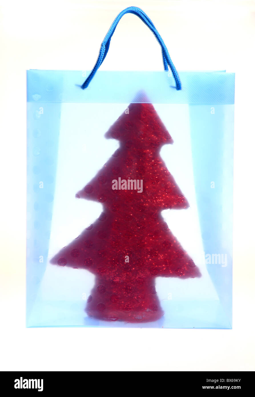 Colorato borsa regalo, riempito con un piccolo albero di Natale artificiale. Foto Stock