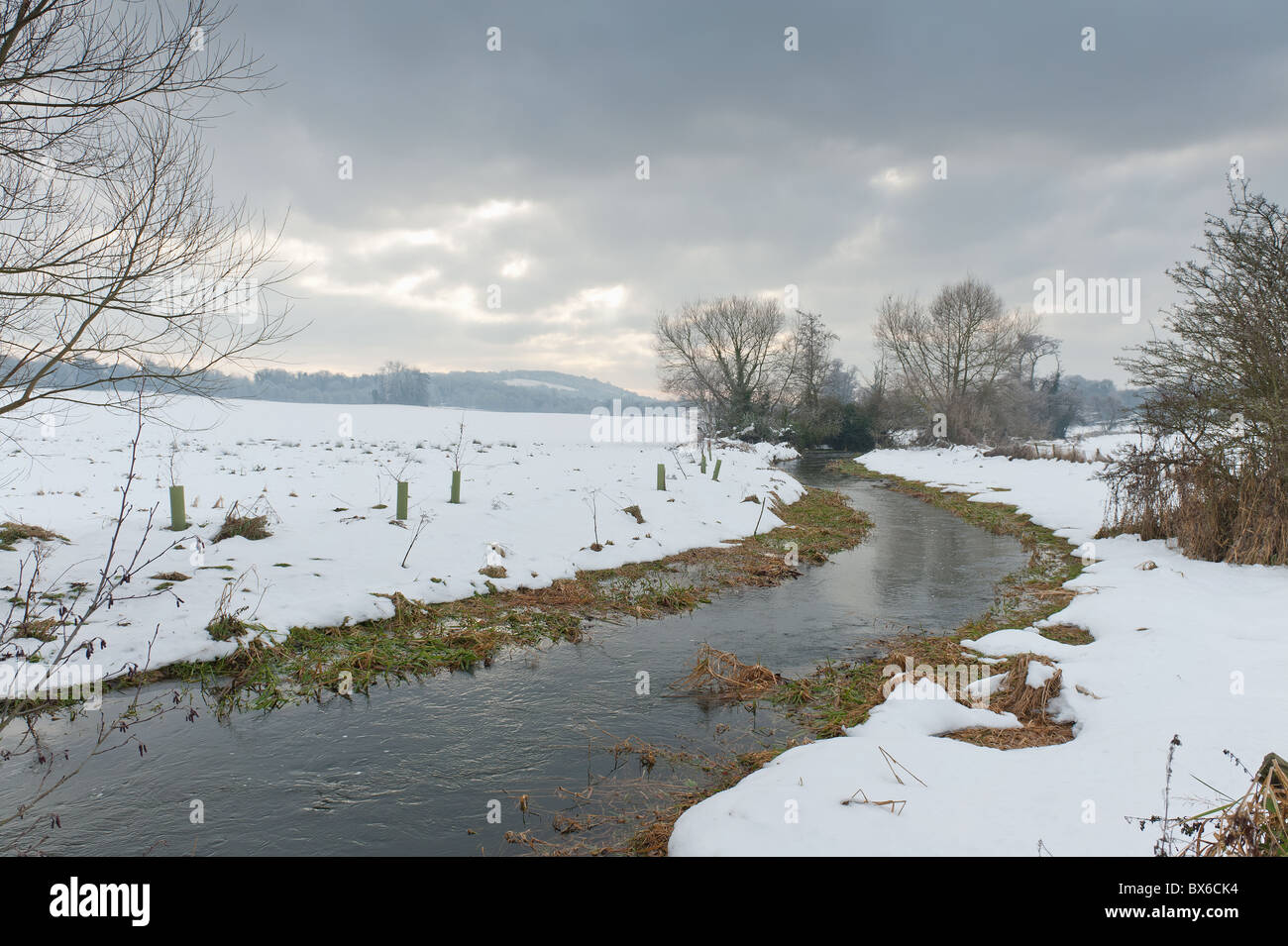 Neve minacciose nuvole nel cielo offuscare la terribilmente freddo fiume Darent Foto Stock
