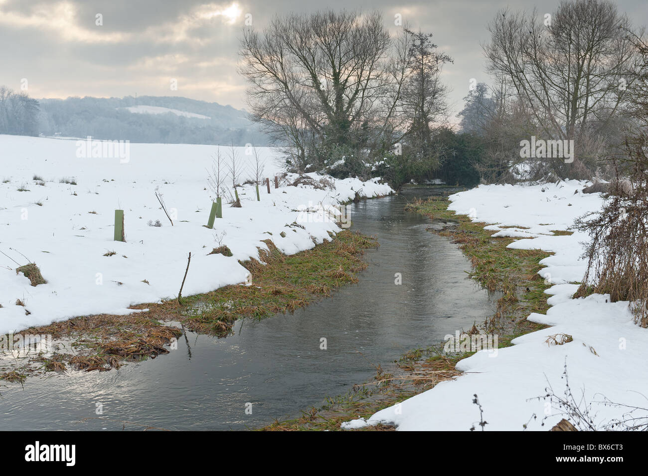 Neve minacciose nuvole nel cielo offuscare la terribilmente freddo fiume Darent Foto Stock